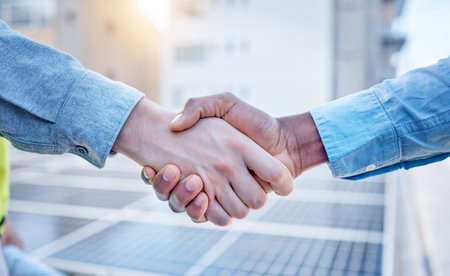 Handshake, engineering and teamwork with people and solar panels for partnership, renewable energy...