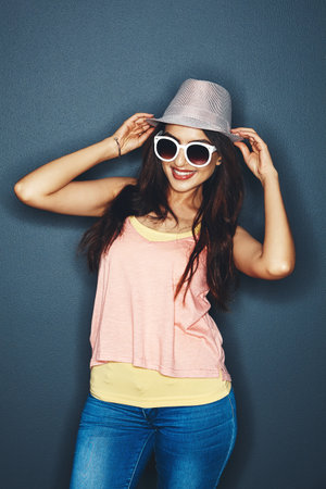 She RSVPed yes. Studio shot of an attractive and fun loving young woman posing against a dark background.の写真素材