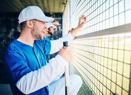 Baseball, dugout and excited man watching game holding bat, competition and winning sport. Fitness, health and serious sports player waiting for turn to play in fun practice match at stadium or fieldの写真素材