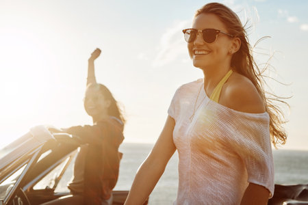 Road trips are the reason for the season. a two happy young women enjoying a summers road trip together.の写真素材