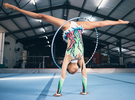 Energy, gymnastics and female with a routine for a performance in a professional arena. Fitness, rhythm and woman athlete or gymnast doing a flexibility and strength trick training for competition.の写真素材