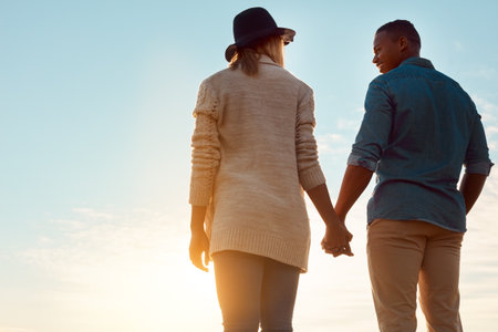 What adventure will love bring today. Rearview shot of a happy young couple holding hands outdoors.の写真素材