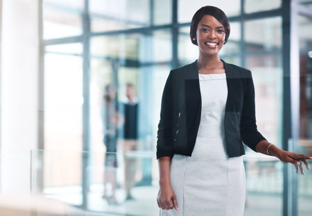 Ambition got me here. Portrait of a confident young businesswoman working in a modern office.の写真素材