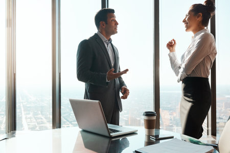 Success is what they love discussing. two businesspeople having a discussion in an office.の写真素材