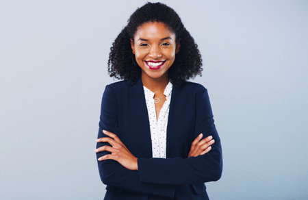 Face your career with self confidence. Studio shot of a confident young businesswoman posing against a grey background.の写真素材