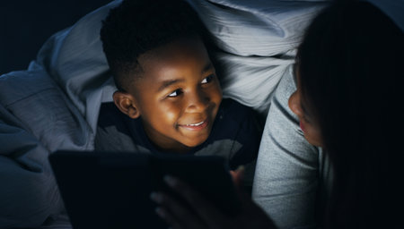 The stories seem way more realistic now. a mother reading a bedtime story to her son using a digital tablet at home.の写真素材
