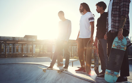 Were ready to hit the ramp. Full length shot of a group of friends skating together on their skateboards at a skatepark.の写真素材