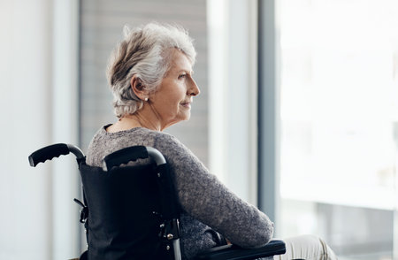 Being alone is such a peaceful place to me. a senior woman looking thoughtful while sitting in her wheelchair.の写真素材