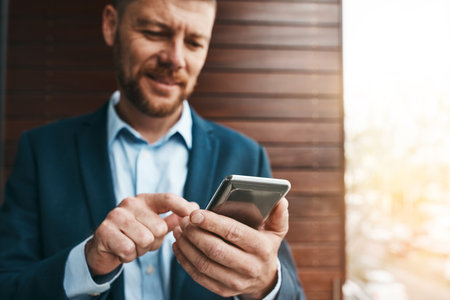 His contacts are always close at hand. a mature businessman using his cellphone on the office balcony.の写真素材