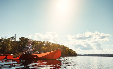 Life is better with an oar. an attractive young woman spending a day kayaking on the lake.の写真素材