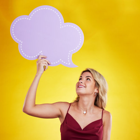 Smile, looking and woman with speech bubble in studio isolated on a yellow background. Poster, word...