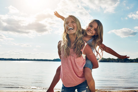 Kids are the most magical humans on earth. a young woman and her daughter spending some quality time at the beach.の写真素材