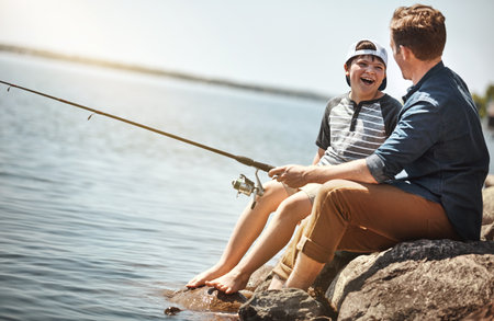 I hope we catch a really big fish. a father and his little son fishing together.の写真素材