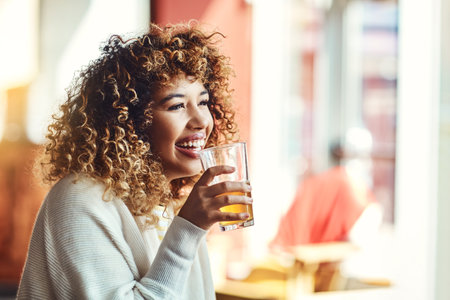 Time to let my hair down. a young woman enjoying a drink at a bar.の写真素材