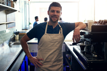 Running a successful cafe quires dedication. Portrait of a mature man working in a coffee shop.の写真素材