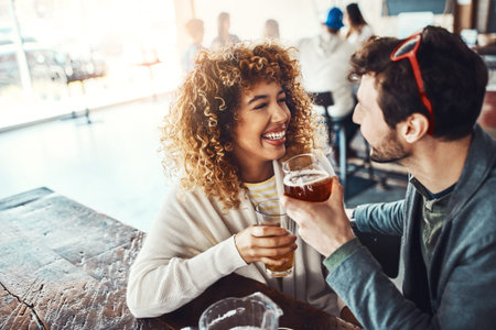 Youre so cute. a happy young man and woman having beers at a bar.の写真素材