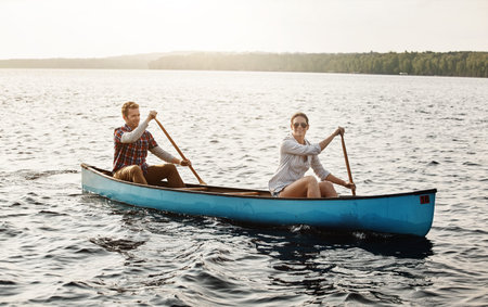 Laid back canoe rides out on the lake. Portrait of a young couple going for a canoe ride on the lake.の写真素材