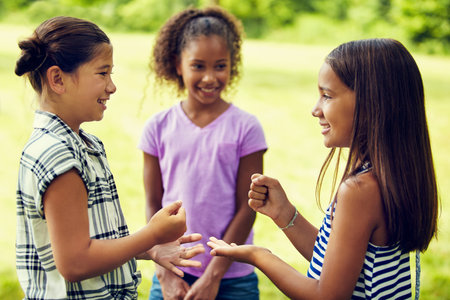 Rock, paper, scissors, who will win. adorable little girls playing rock, paper, scissors outdoors.の写真素材