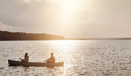 The lake is always a great getaway. a young couple rowing a boat out on the lake.の写真素材