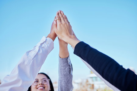 Business people, hands and high five for teamwork, winning or success in unity in the outdoors. Happy group of employees putting hand together for collaboration, celebration or victory in solidarityの写真素材