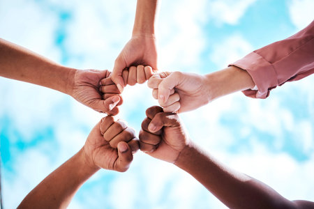 People, hands and fist bump in collaboration, trust or unity for partnership, community or diversity...