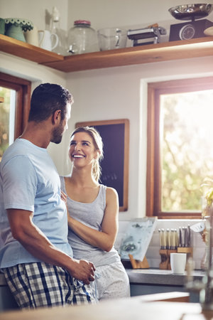 Starting the day with a good chat. a couple standing together in their kitchen.の写真素材