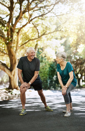 Prolonging good health through fitness. a senior couple warming up before a run outside.の写真素材