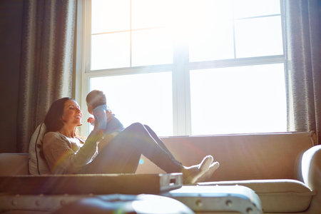 Nothing quite like a mothers love. a young woman bonding with her baby boy on the sofa at home.の写真素材