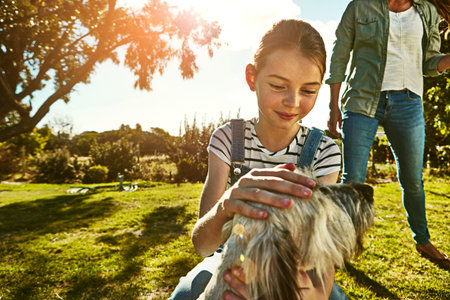 You sure are the cutest little doggy ever. a little girl and her mother playing with their dog at the park.の写真素材