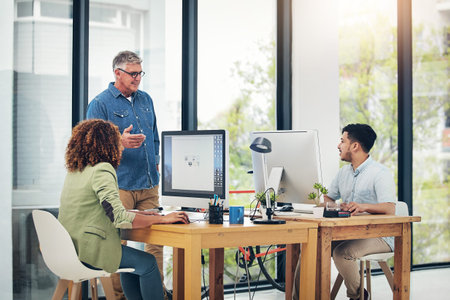 Theyre eager to hear his advice. a creative entrepreneur offering advice to two new colleagues in...