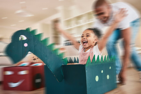 Dragon, cardboard and father playing child in fantasy game bonding in a living room or home lounge together. Blur, happy and single parent or dad having fun with kid or daughter excited to playの写真素材