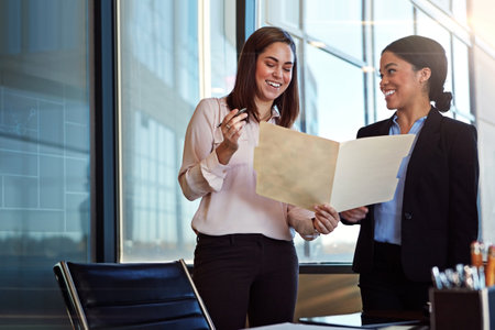Getting it right together. two young lawyers having a conversation in their office.の写真素材