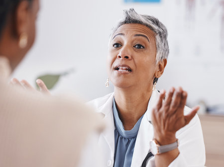 Senior woman, doctor and consultation with question, listen or conversation for healthcare, wellness or advice. Elderly medic, consulting patient and talking in hospital, clinic or listen for problemの写真素材