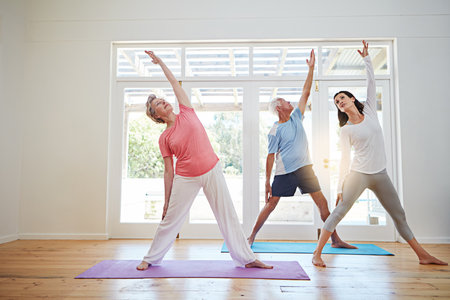 Your goals are never out of reach. Full length shot of a female yoga instructor working with a senior couple.の写真素材
