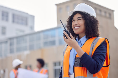 Construction worker, woman with walkie talkie and communication, engineering and architect at work site. Inspection, technology and happy female contractor, building industry and labor outdoorの写真素材