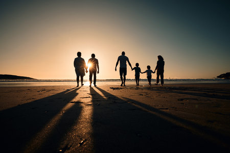 Silhouette, beach and big family holding hands in sunset on a holiday or vacation at sea or ocean...