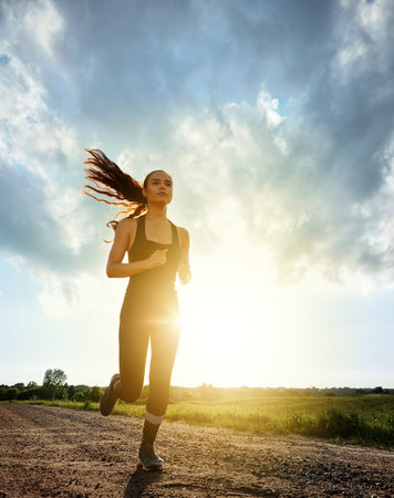 Motivation gets you started, but habit keeps you going. a fit young woman out for a run on a beautiful day.の写真素材