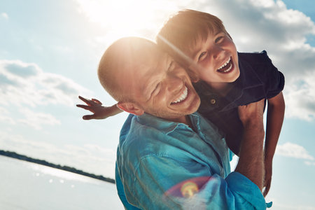 Trips to the beach make for a fun filled day. a middle-aged man and his young son spending some quality time at the beach.の写真素材