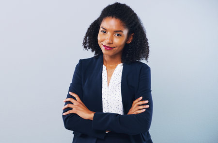 If you dont know me yet, you will now. Studio shot of a confident young businesswoman posing against a grey background.の写真素材