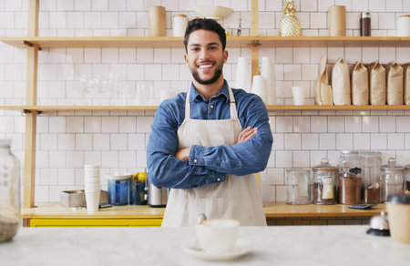 Our cafe is rated tops for service. Portrait of a young waiter standing behind a counter in a cafe.