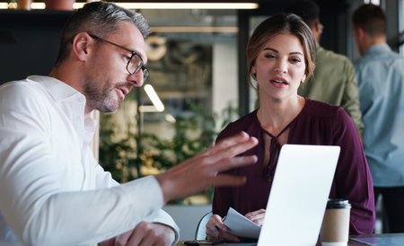 Whatever the plan, theyll make it work. a businessman and businesswoman using a laptop and having a discussion in a modern office.の写真素材