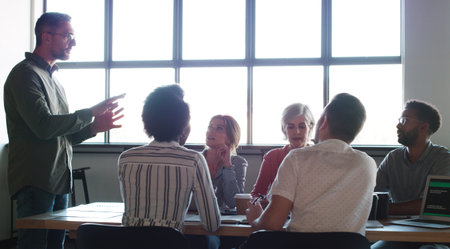 Good managers get the team to follow their lead. a group of businesspeople having a meeting in a...