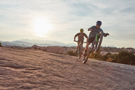 Mountain biking pushes ones adrenaline to levels unimaginable. Full length shot of two men out mountain biking together during the day.の写真素材