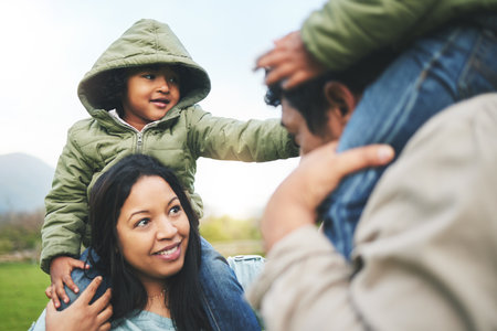 Family, happy and smile outdoor in nature for quality time, love and care outdoor. Man, woman or mom and dad with kids together at a park for happiness on vacation, holiday or travel trip in winterの写真素材