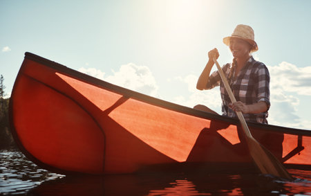 Shes happiest on the river. an attractive young woman spending a day kayaking on the lake.の写真素材