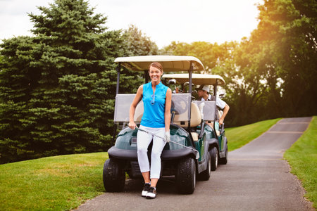 Improving my game. Full length portrait of an attractive young woman leaning against a golf cart on a golf course.の写真素材