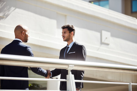 Meeting a fellow entrepreneur is always a good thing. young handsome businessmen shaking hands on a...