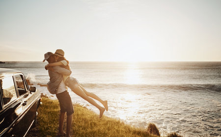 This day just couldt get any better. an affectionate young couple enjoying a road trip along the coast.の写真素材