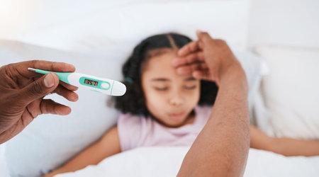 Parent, hands and thermometer with sick kid checking fever or temperature for flu or cold on bed at...