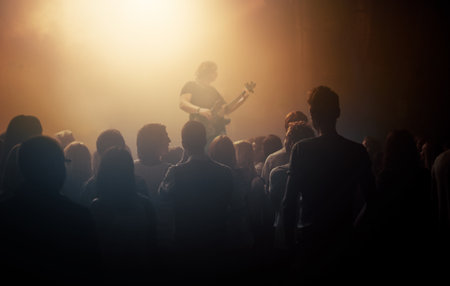Dark crowd, musician and people at a concert for a guitar performance, music festival and band. Event, show and an audience enjoying live night entertainment, performer or an artist at a clubの写真素材